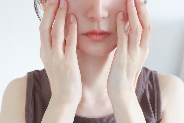 頬に手を当てる女性